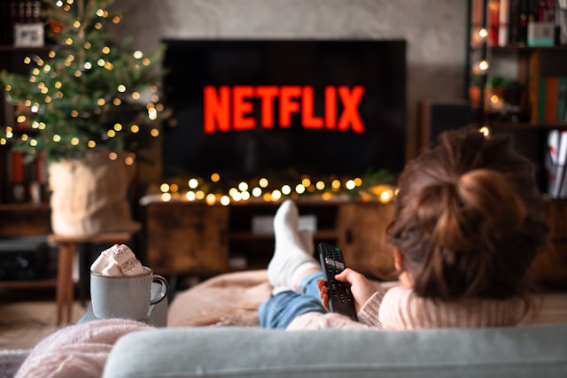 Kindheitszauber einfangen: Ein fröhlicher Abend eines kleinen Mädchens auf der Couch mit Netflix